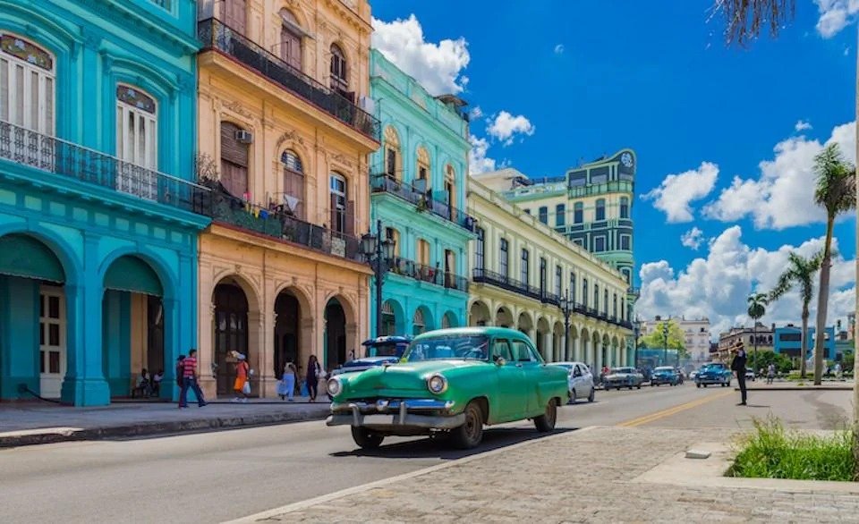 Rows of colorful vintage American cars from the 1950s parked along a Havana boulevard